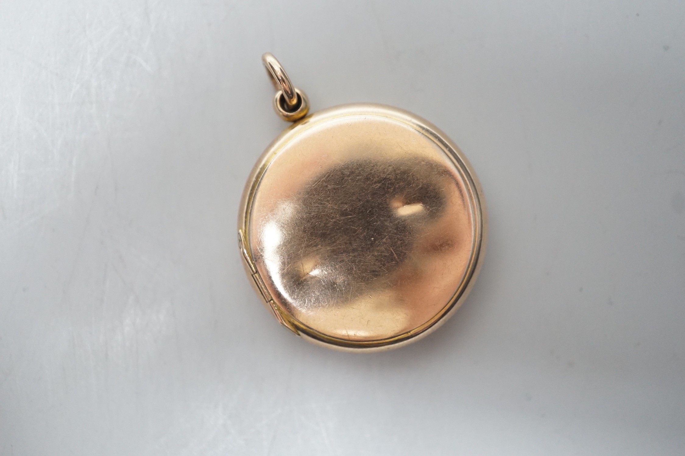 A 9ct gold mounted circular triptych locket, diameter 29mm, gross weight 10.8 grams.